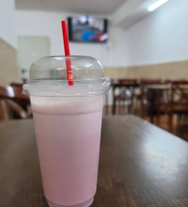 Batido rosa sobre una mesa de madera dentro del local