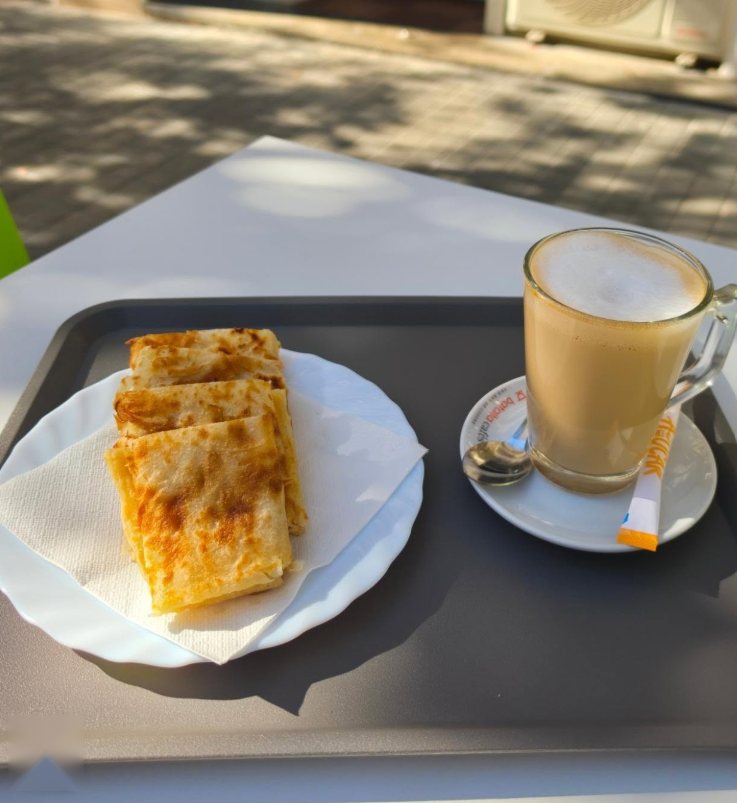 Plato de msemen dorado con un café con leche