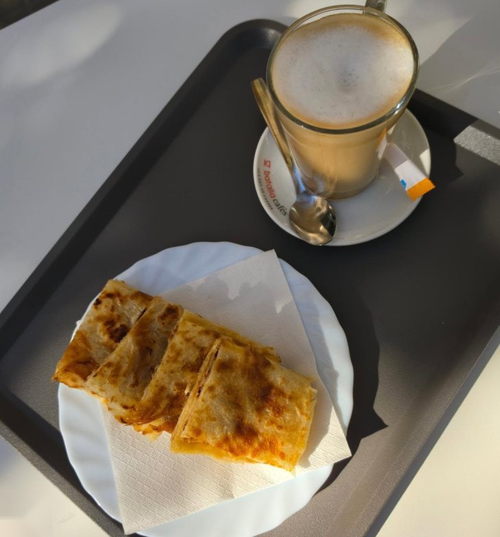Msemen cortado en cuadrados junto a un café con leche