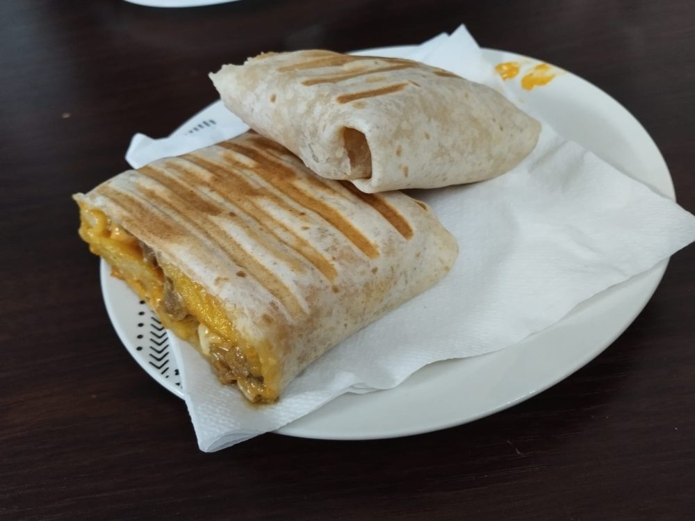 Dos mitades de taco a la plancha sobre un plato con servilleta