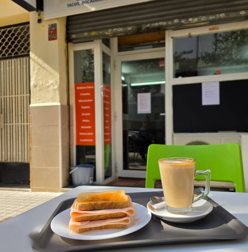 Tostada con jamón y café con leche en la terraza del local